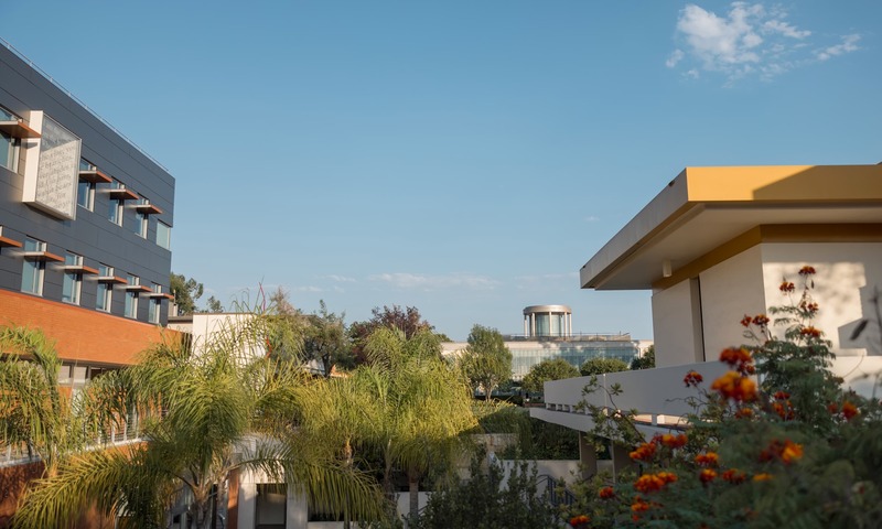 Image shows top of Biola's library through trees and buildings