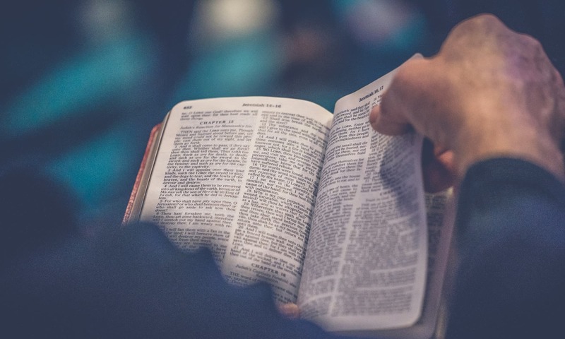 image shows hands holding a Bible