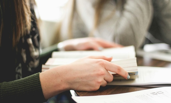 Image shows a person reading a book