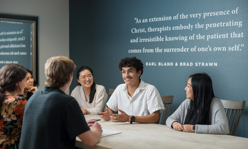 Image shows students talking around a table