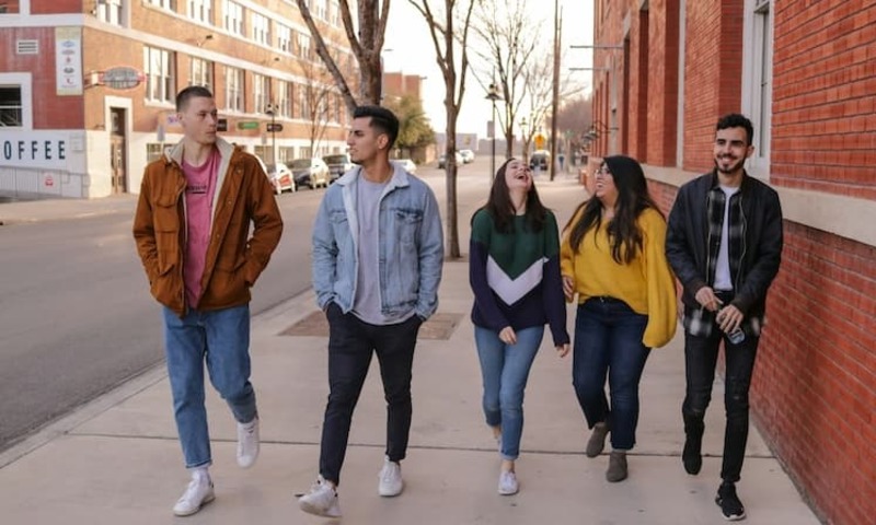 three men and two women walking