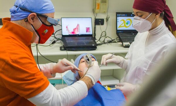 Image shows dentist and assistant working on patient