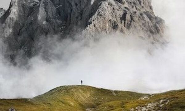 Peak of mountain with one person on top