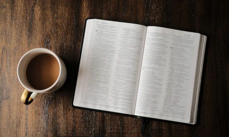 coffee mug and bible on desk