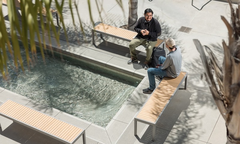 image shows two student talking by the reflection pool