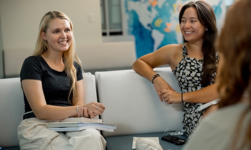 three women involved in a discussion and smiling 