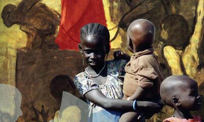 African children and shadow of a man reading a newspaper with Christ in the background