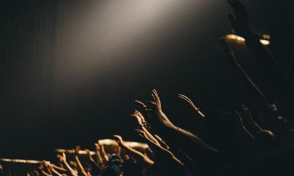 Hands raised in worship setting.