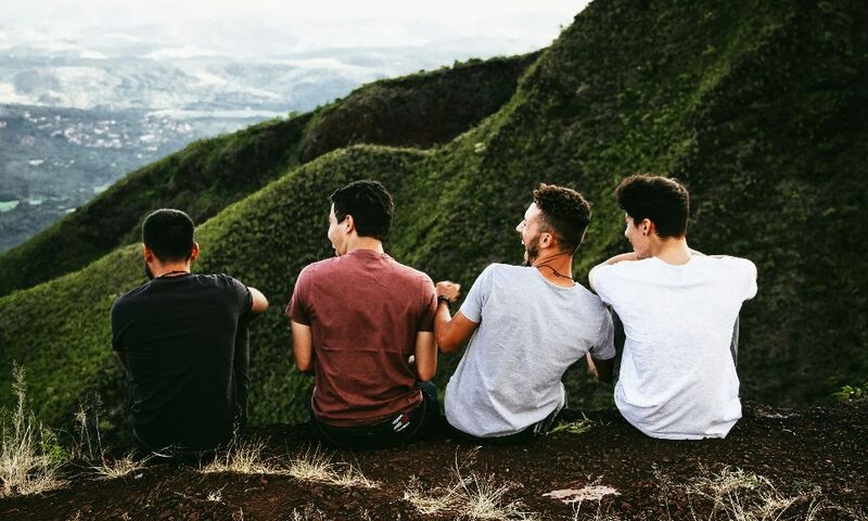 Four friends looking at mountains and laughing 
