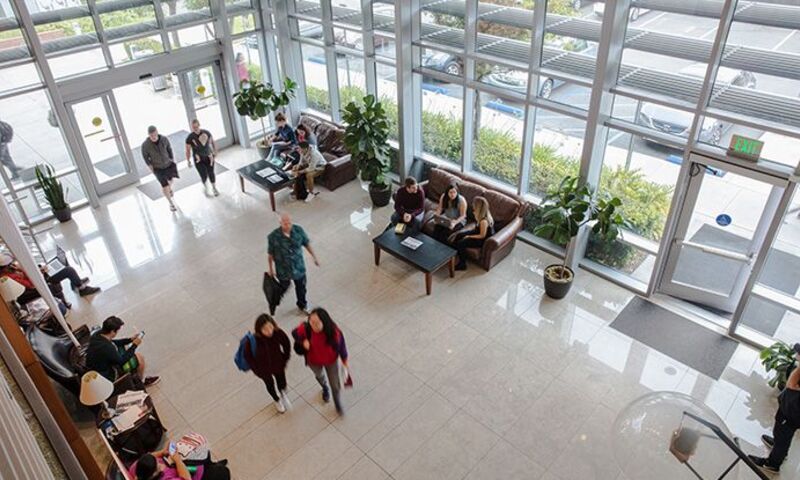 Image shows Crowell School of Business building lobby with students walking through 