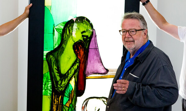 Peter Brandes stand in front of one of the stained glass windows he created for Calvary Chapel