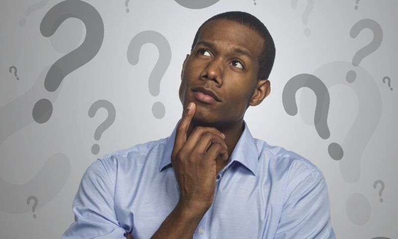 Image shows man with a questioning look surrounded by images of question marks