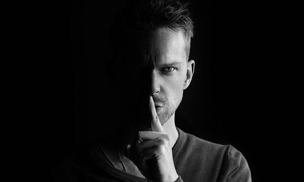 Man shushing camera in black and white