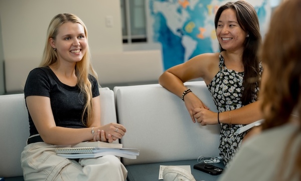 three women involved in a discussion and smiling