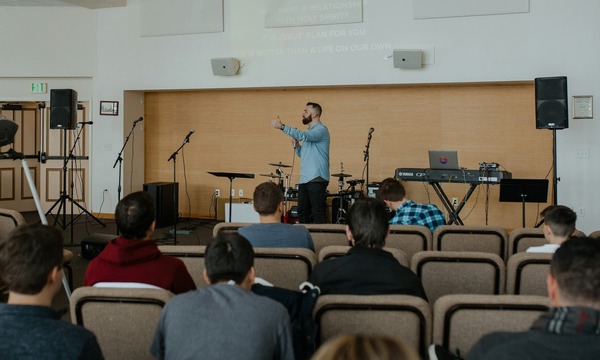 image shows a preacher talking to students
