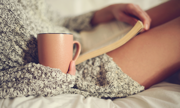 girl holding coffee mug and book