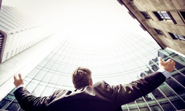 man looking up on building