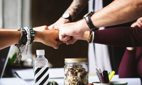 Four people giving fist bumps