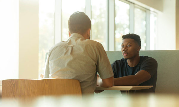 Image of two males meeting