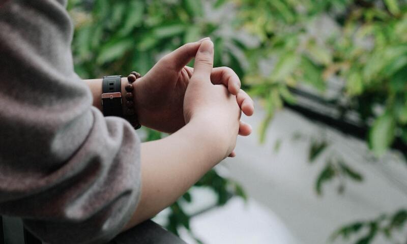 Image shows a pair of folded hands, as in deep thought