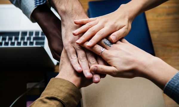 Hands of many people layered in a handshake