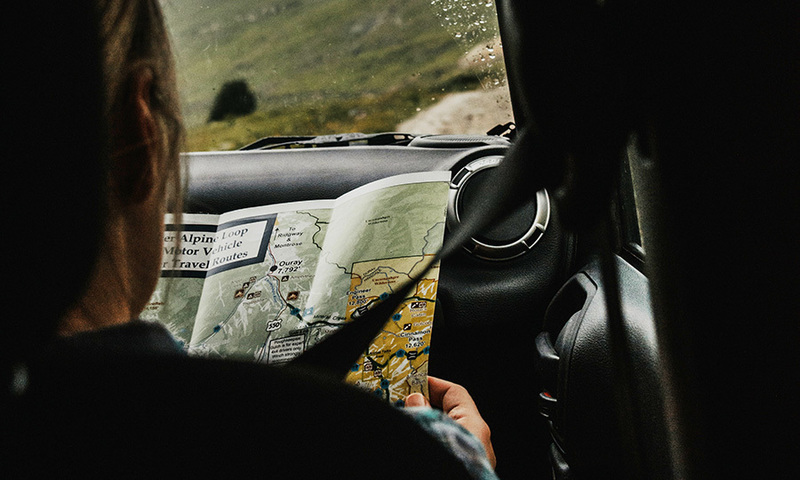 A person in a vehicle examines a roadmap.