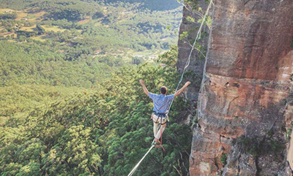 man walking across tightrope