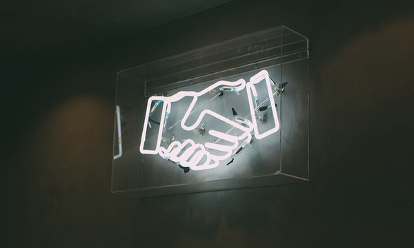 neon light of two hands shaking