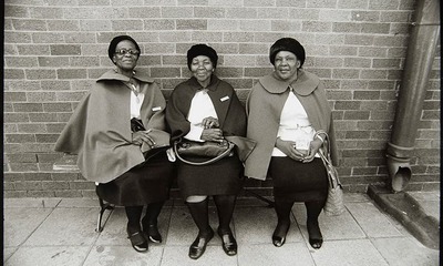 photograph of three women sitting on a bench