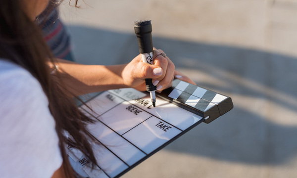 Biola film student writes on a clapboard