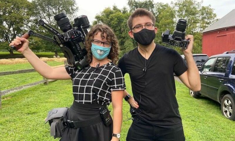 Image of Rebecca Baliko (left) and Andy Brewster (right) holding film cameras
