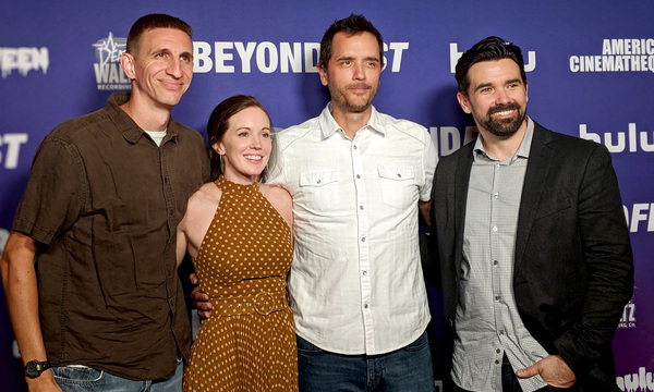 Three men and a woman posing for a photo