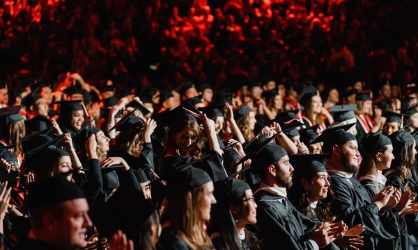 Graduates turning the tassel on their caps.