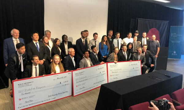 A group of students posing for a photo with oversized checks