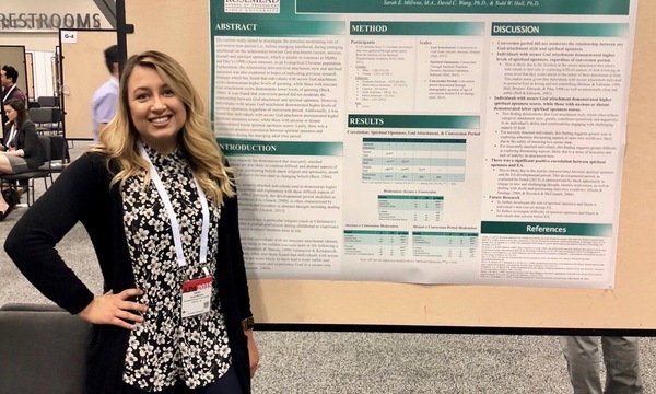 Sarah Millwee standing in front of a display with text and charts