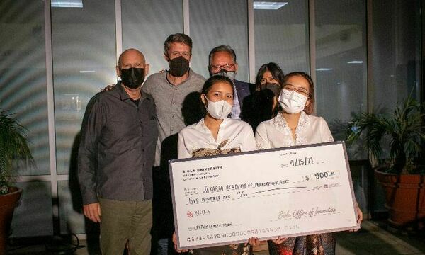 students holding a check
