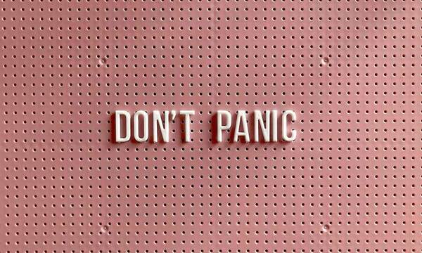 Photo of a corkboard with words "don't panic"