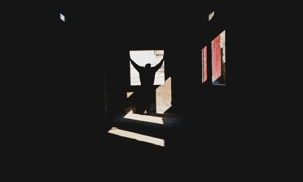 silhouette of man standing in a window