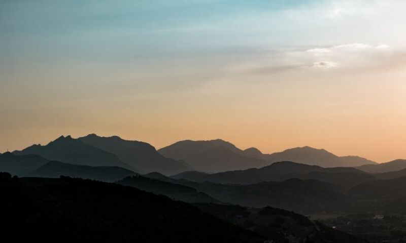 Landscape of mountains over sunset.