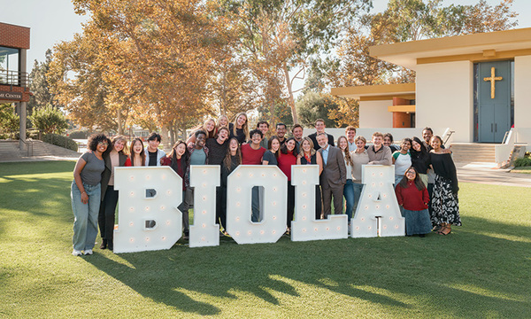 group of students in front of BIOLA signage