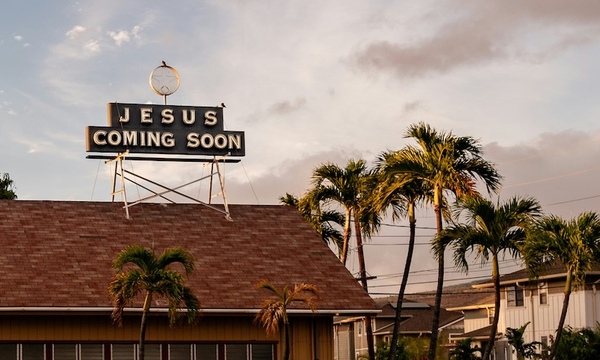 image shows a Jesus is Coming sign on top of a roof