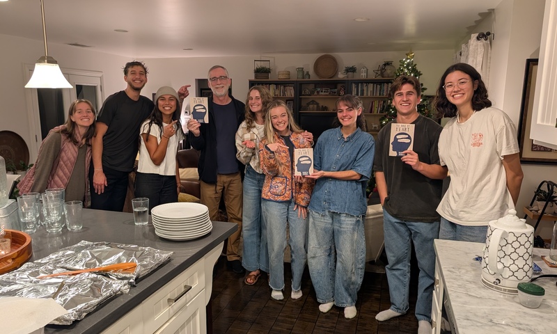 image shows Ken Berding with students holding up his book