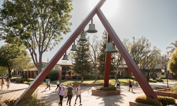 image shows students walking under the Bell Tower