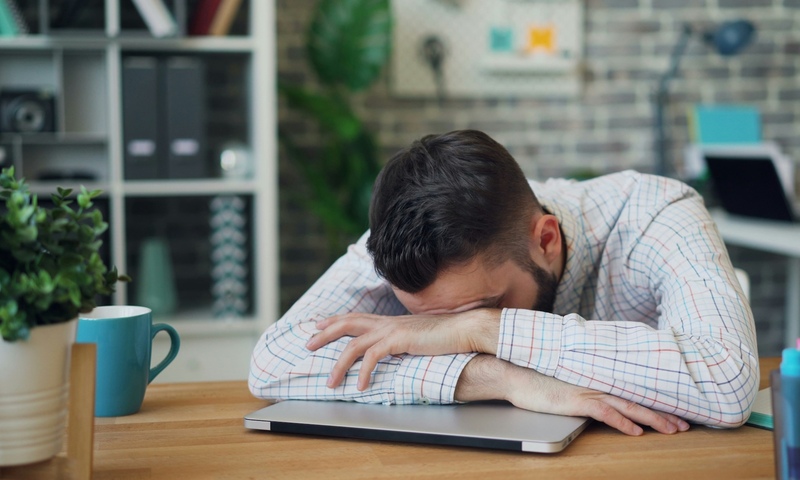 image shows tired man at computer