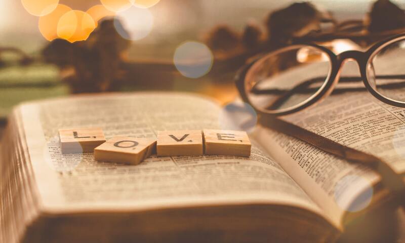 image shows the word love spelled out over an open Bible