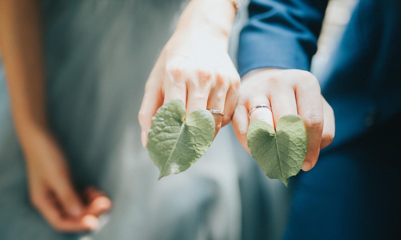 image shows two hands with rings