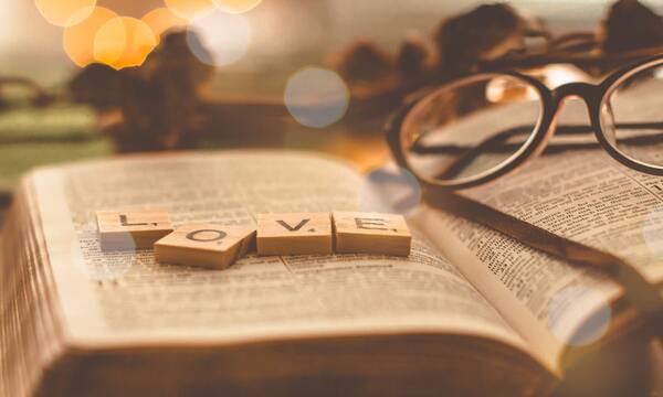 image shows the word love spelled out over an open Bible