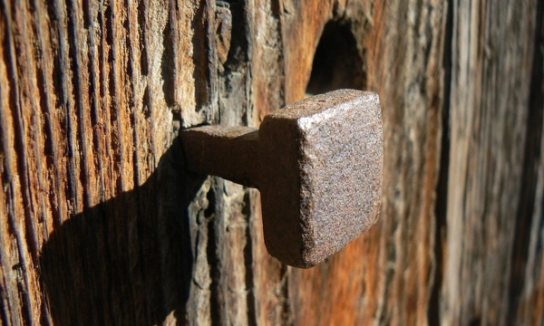 image shows a nail in wood