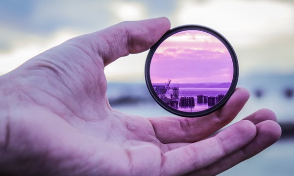 image shows a hand holding a lens