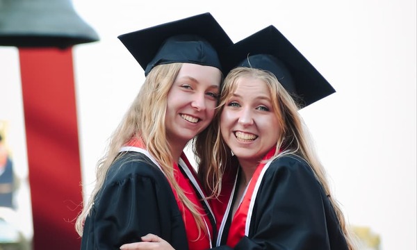 image shows Hope and Heather in their graduation regalia 